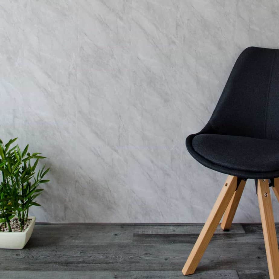 Black chair with wooden legs against a gray wall_10mm_Lightning_Marble_Gloss_Shower_Panel_1M_x_2.4M_8