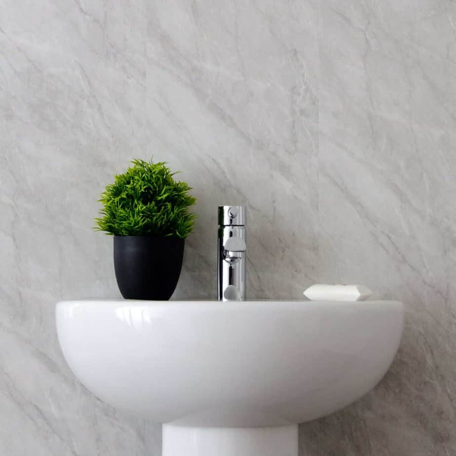 White sink with a plant and faucet against a gray marble wall_10mm_Lightning_Marble_Gloss_Shower_Panel_1M_x_2.4M_8