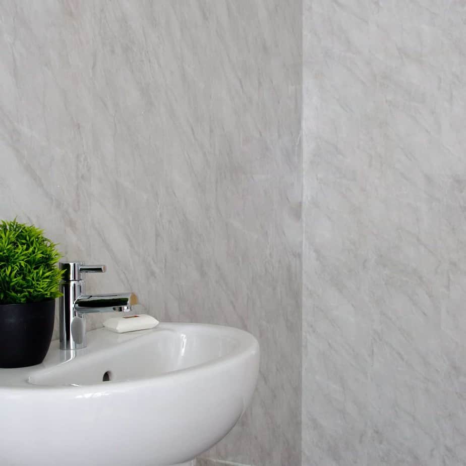 White sink with a green plant and silver faucet against a gray marble wall_10mm_Lightning_Marble_Gloss_Shower_Panel_1M_x_2.4M_8
