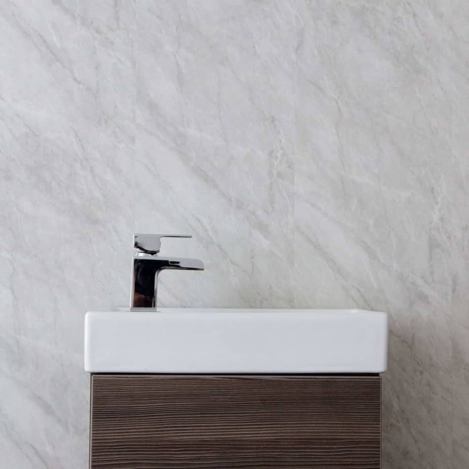 Modern bathroom vanity with white sink and wooden cabinet against a gray marble wall_10mm_Lightning_Marble_Gloss_Shower_Panel_1M_x_2.4M_8