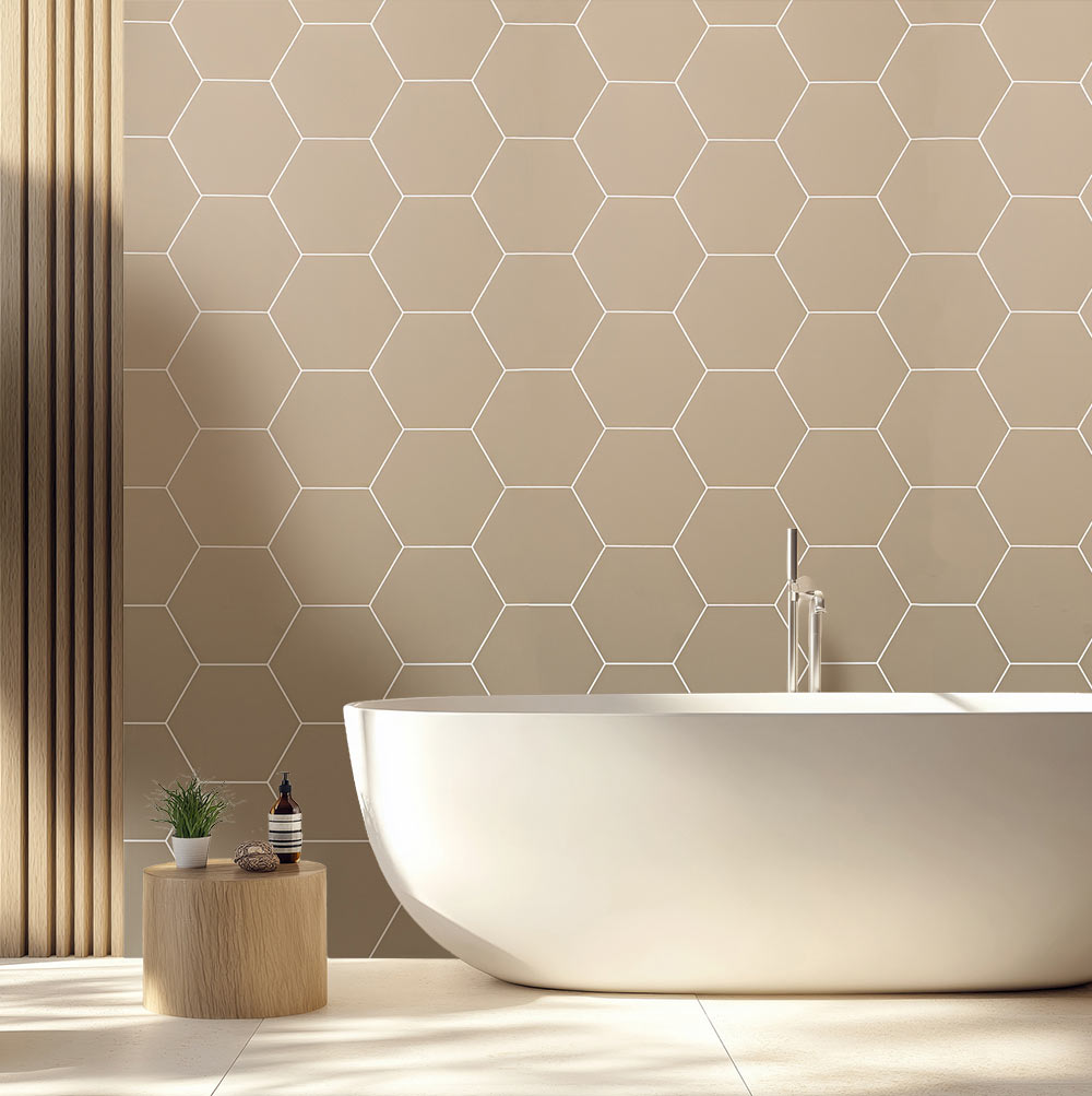 Modern bathroom with a freestanding bathtub against a hexagonal tile wall.