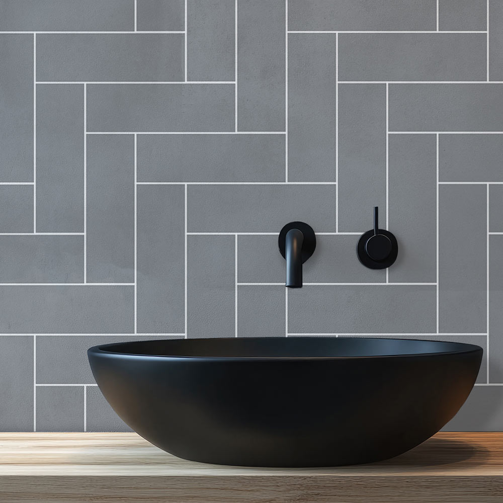 Black sink against a gray tiled wall